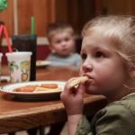 Two young children eat fish and chips, the Daily Special on Fridays at Countryside Pizza and Grill