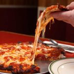 A slice of cheesy pepperoni pizza pulled from the full pie at Countryside Pizza and Grill